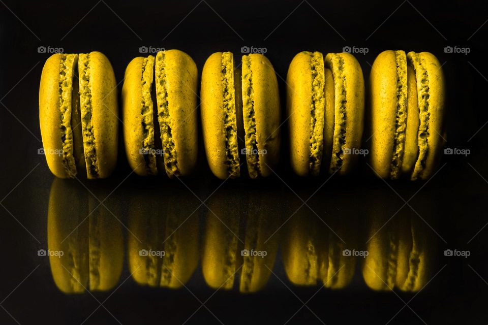 Yellow macaroons on black background 