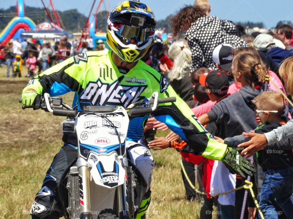 Motorcycle Stunt Rider. Motorcycle Stunt Performer Giving High Five To His Fans
