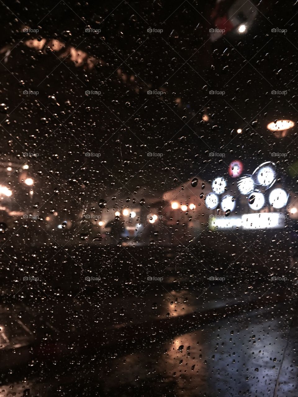 Watching the rain through the window. The night lights blur through the water.