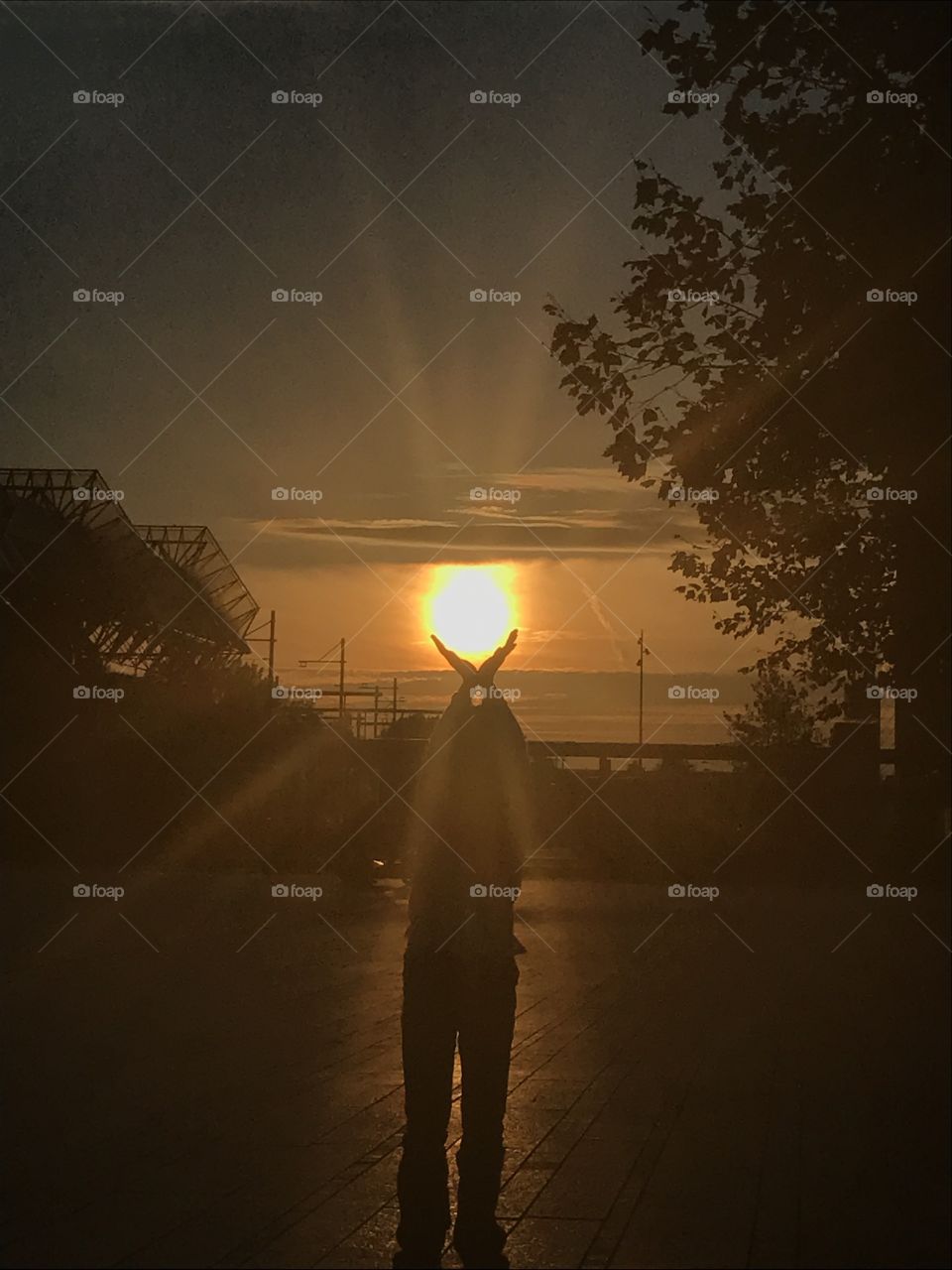 Little girl holds the sun in her hands