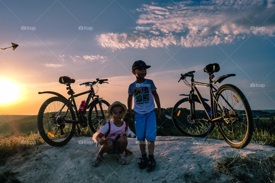 children on the mountain next to bicycles