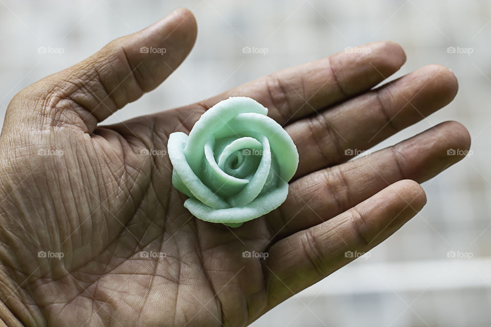 The hand holding the Thai dessert flower green or Aalaw candy.