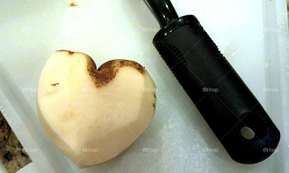 heart shaped potato being peeled