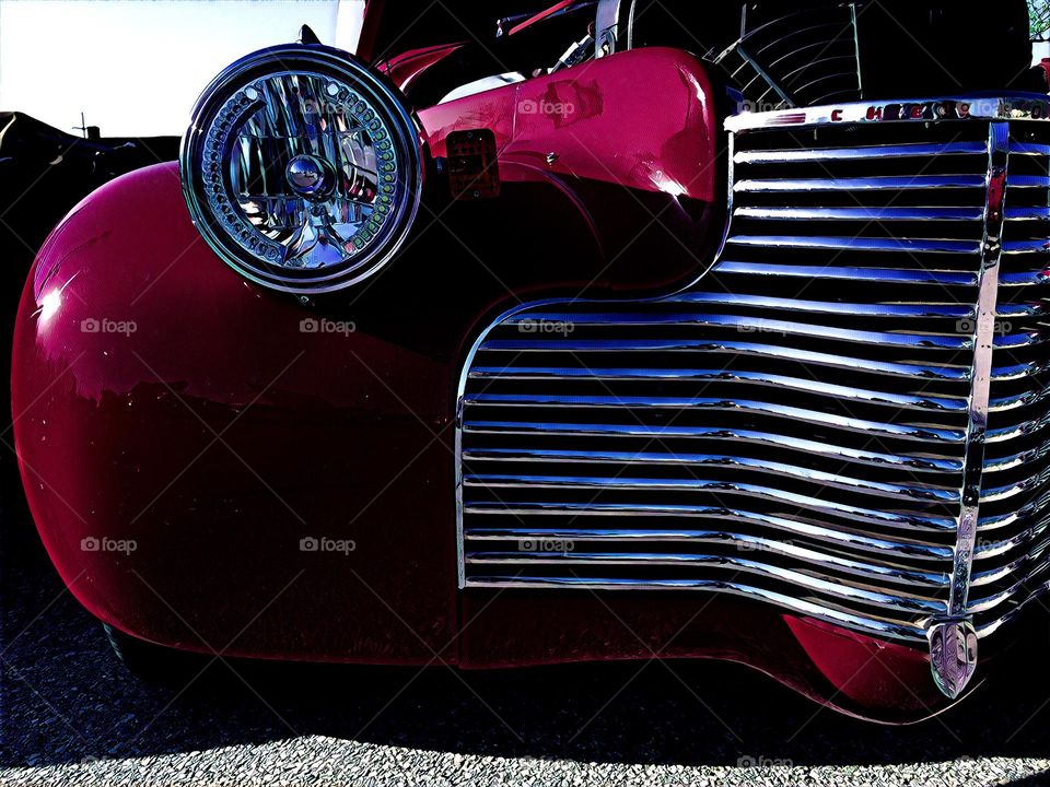 Classic car show, brightly colored classic car, view from the front of a classic car, grill on a classic car 