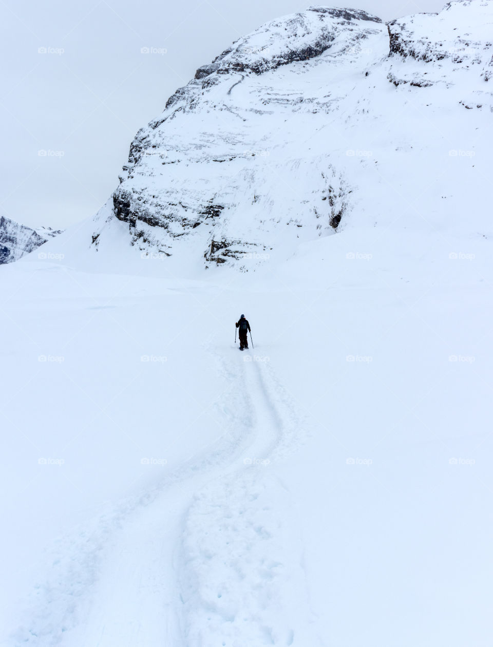 Hiking with snow shoes through powdery white winter landscape.