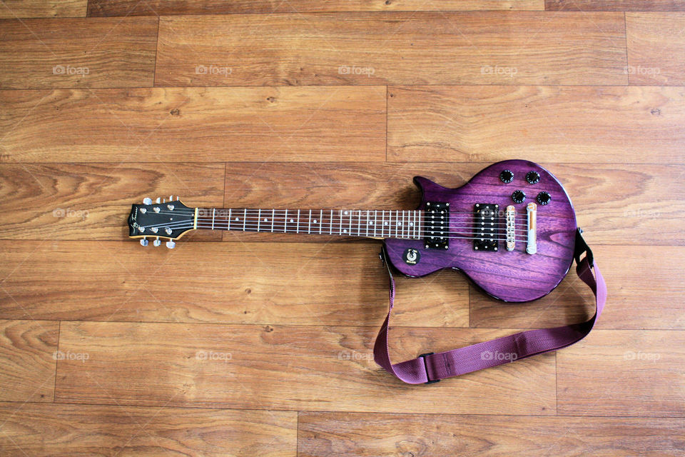 full view of a purple electric guitar