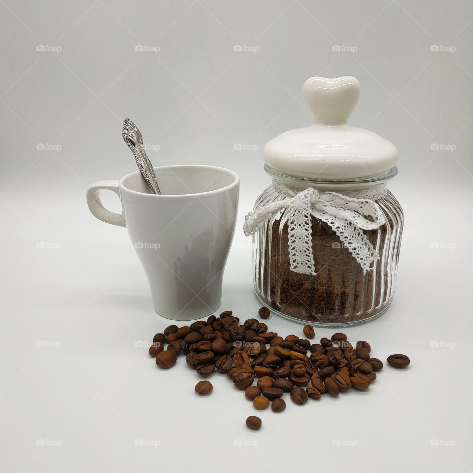 Jar filled with coffee and roasted coffee beans on white background, mug