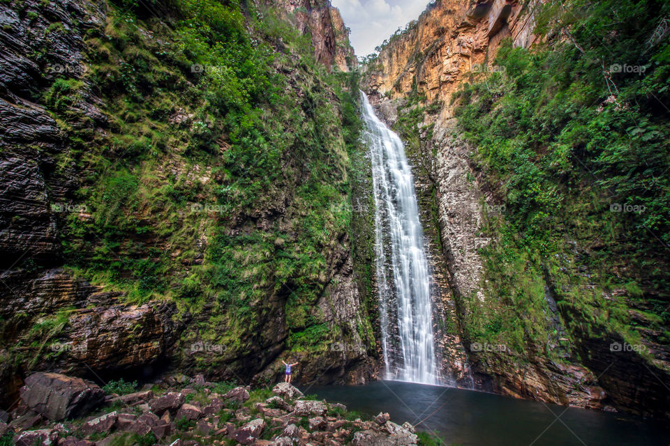 Person appreciating a high waterfall