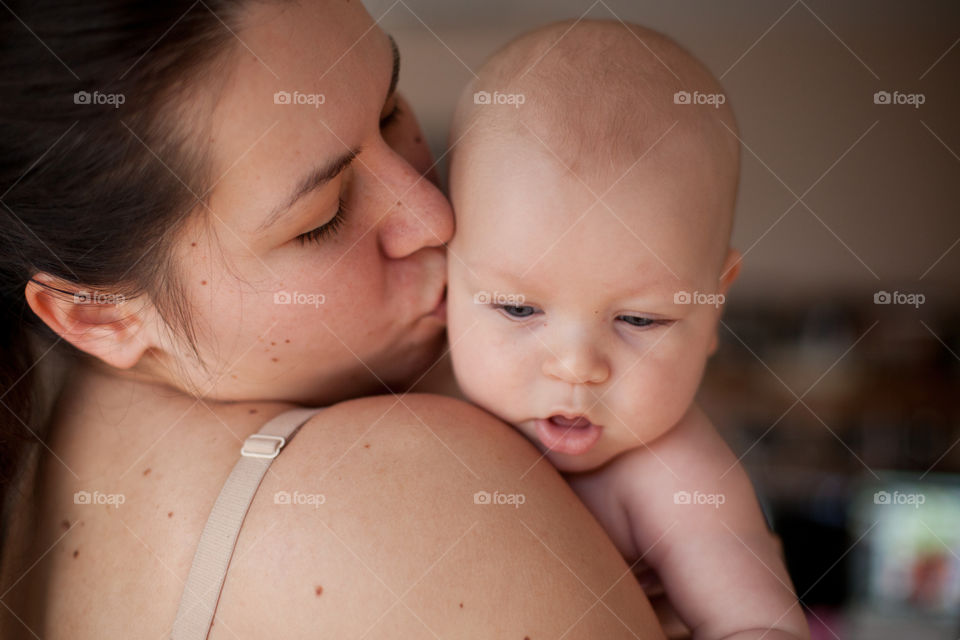 Cute little baby boy over moms shoulder 