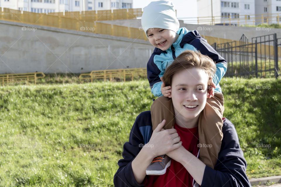 The brothers have fun outdoors in the park. The older brother takes care of the younger one and teaches him in a fun and easy way.