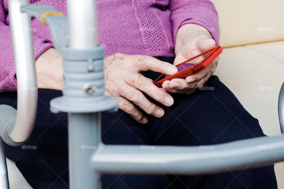 older woman with smartphone and orthopedic walker