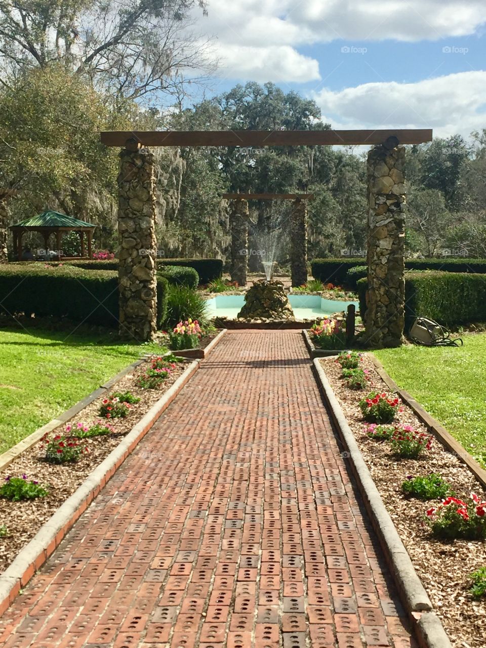 Pathway entrance to park in the Spring with a fountain