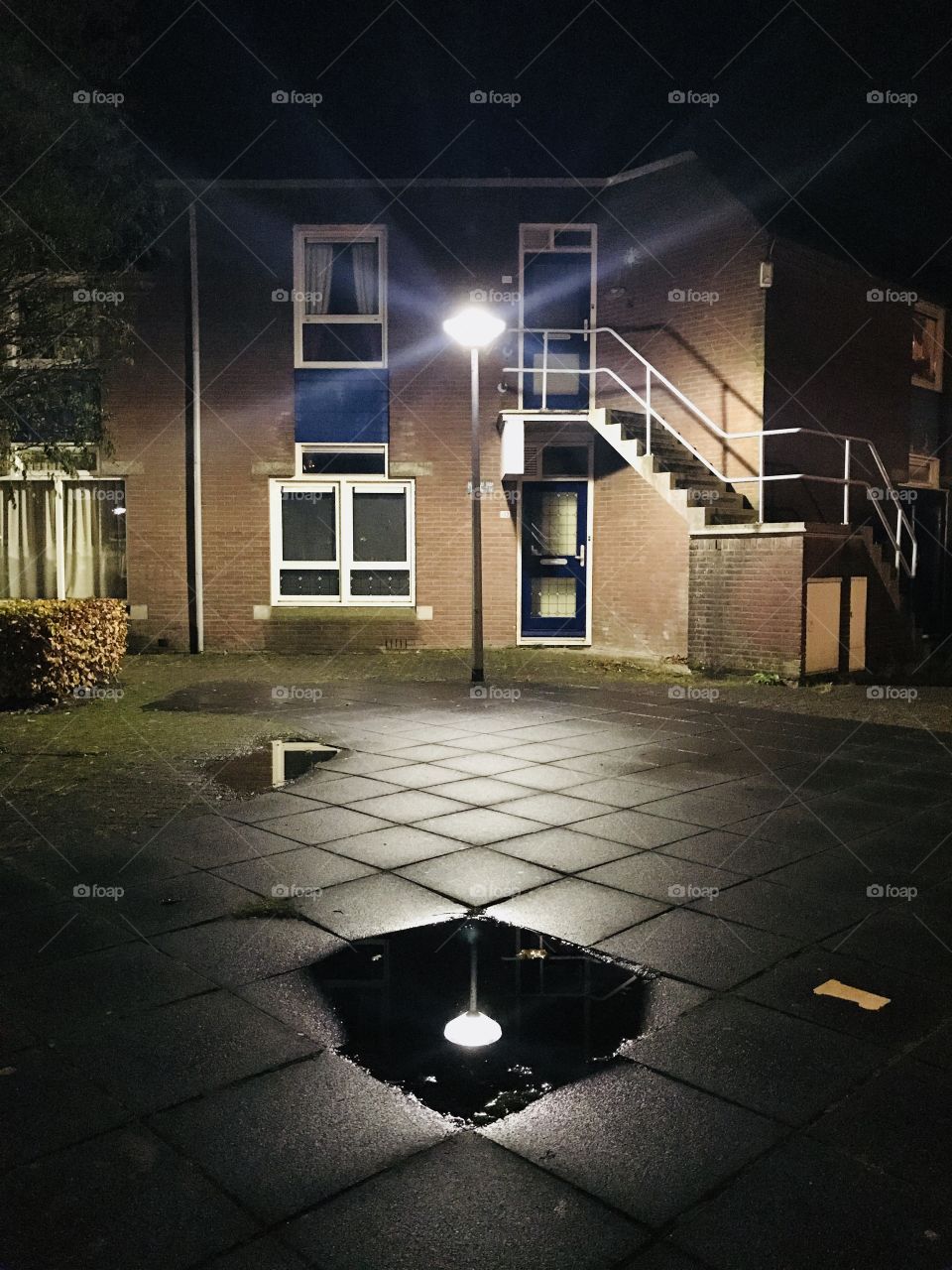 Reflection of a street lamp in a little pool of rain water 