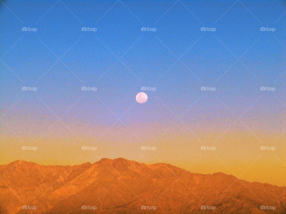 vista de la luna sabiendo sobre la cordillera de los Andes