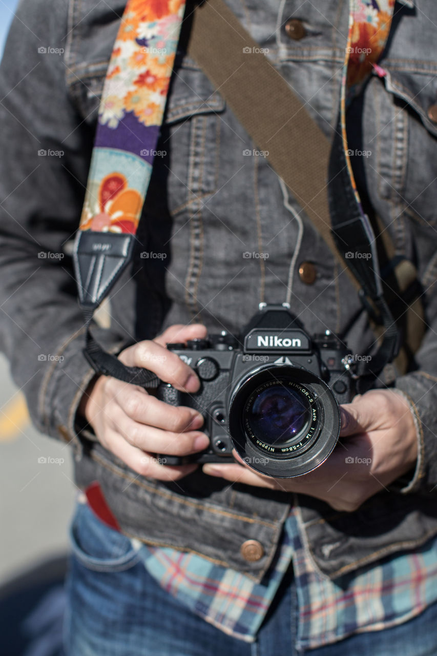 A person holds his vintage Nikon Camera