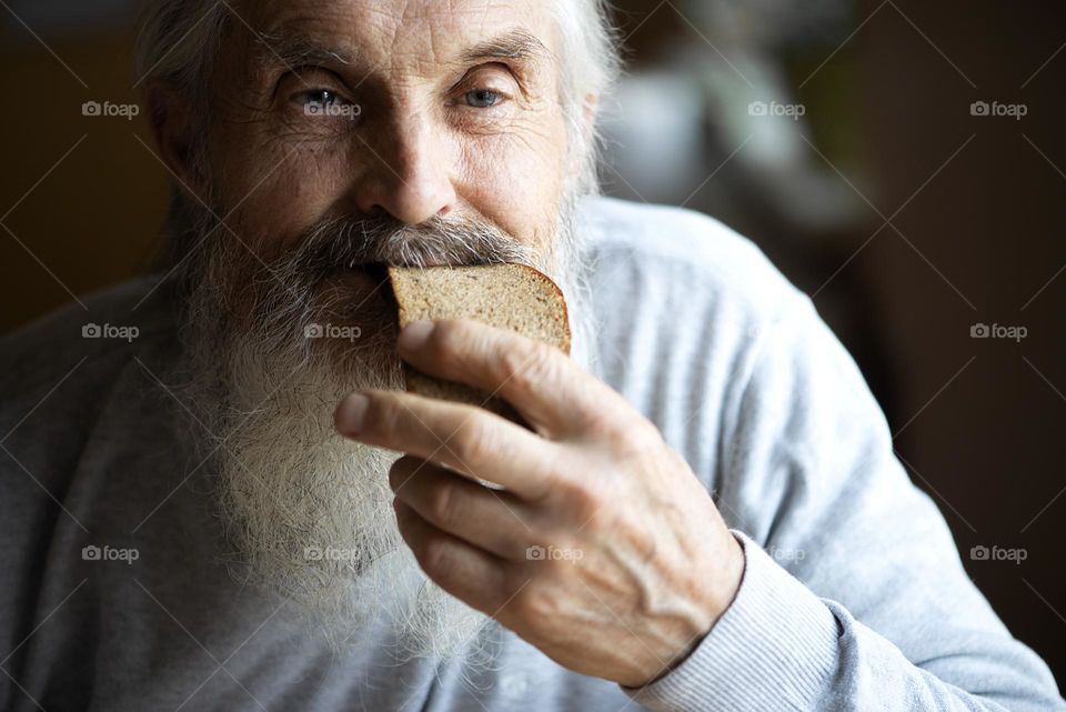 senior man eating bread
