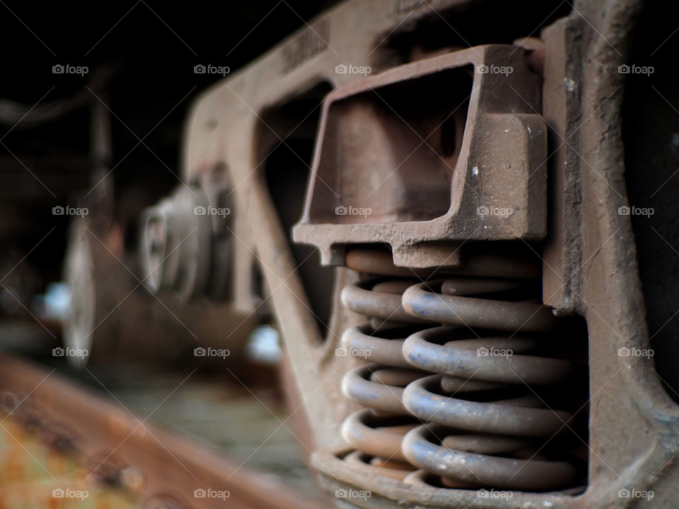 An old and rusty shock absorber of a train