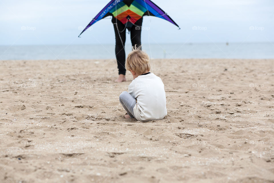 Boy on the beach with his dad and a kite