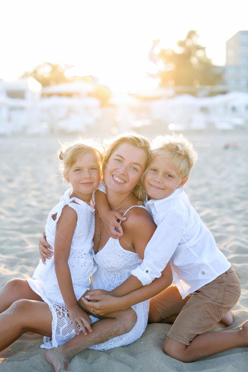 Beautiful family, mom, son, daughter in sunny ray