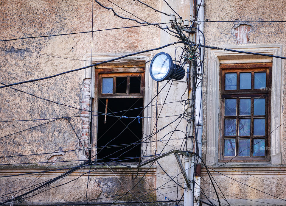 old lighting post with many electric supply wires or cables for telephone communication