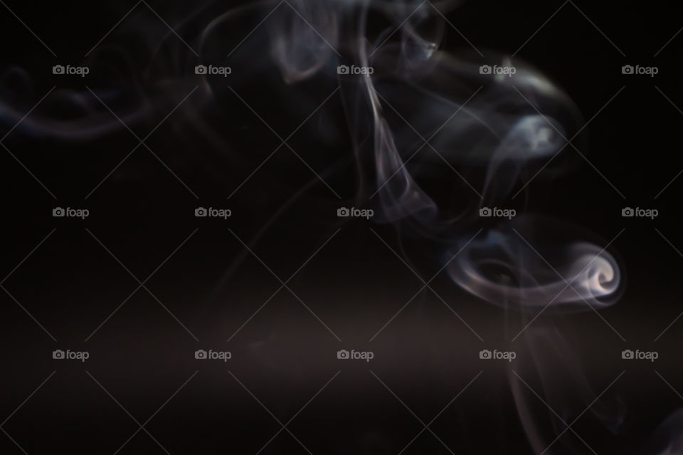 Smoke scented candles on a black background