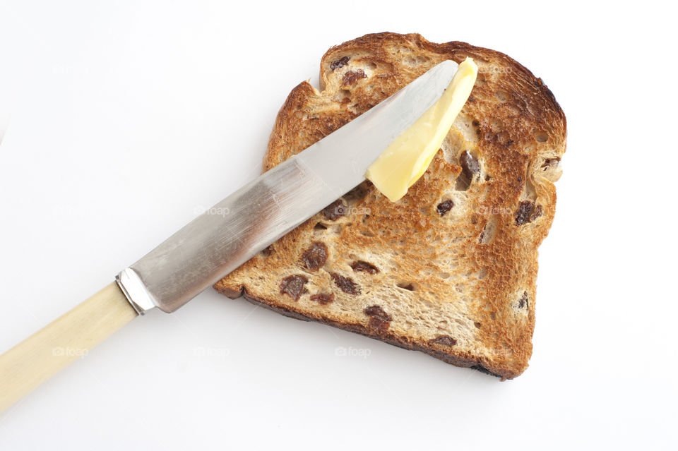 Knife with butter over a slice of bread