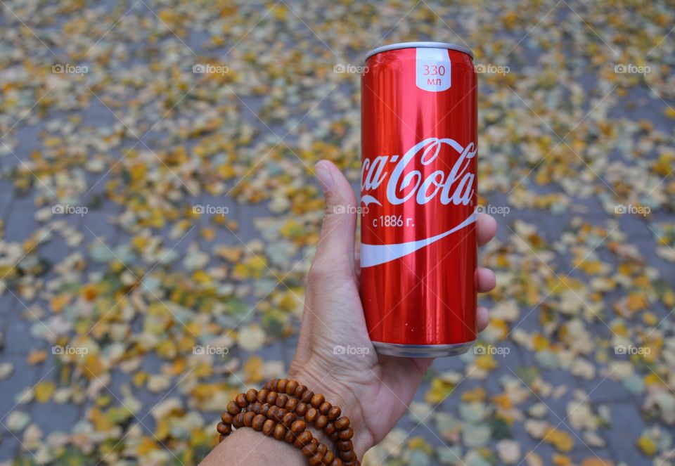 coca cola in hand autumn background, drinking coca cola outdoor