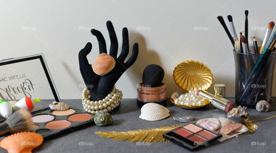 Nautical themed makeup flat lay whit shell and pearls 