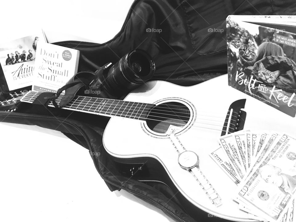 Fun photo of guitar with guitar case filled with books, money, and camera for trip! 