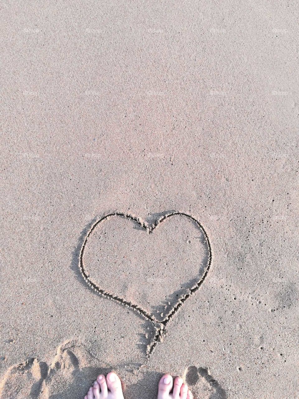 Heart drawn on sandy beach