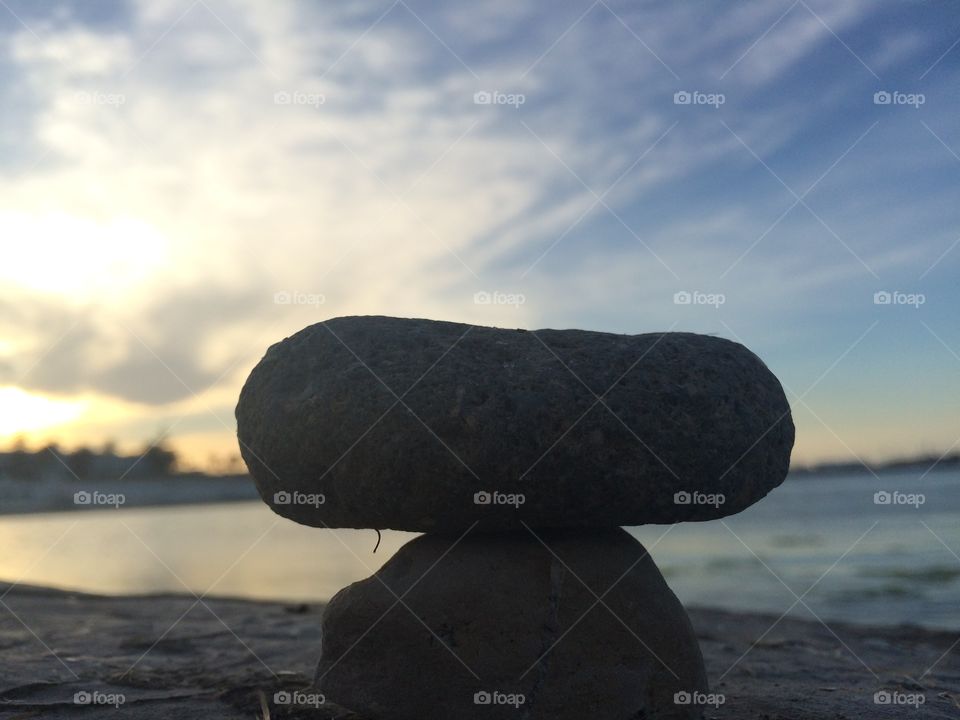 sunset behind rocks. focus on rock in front of sunset 