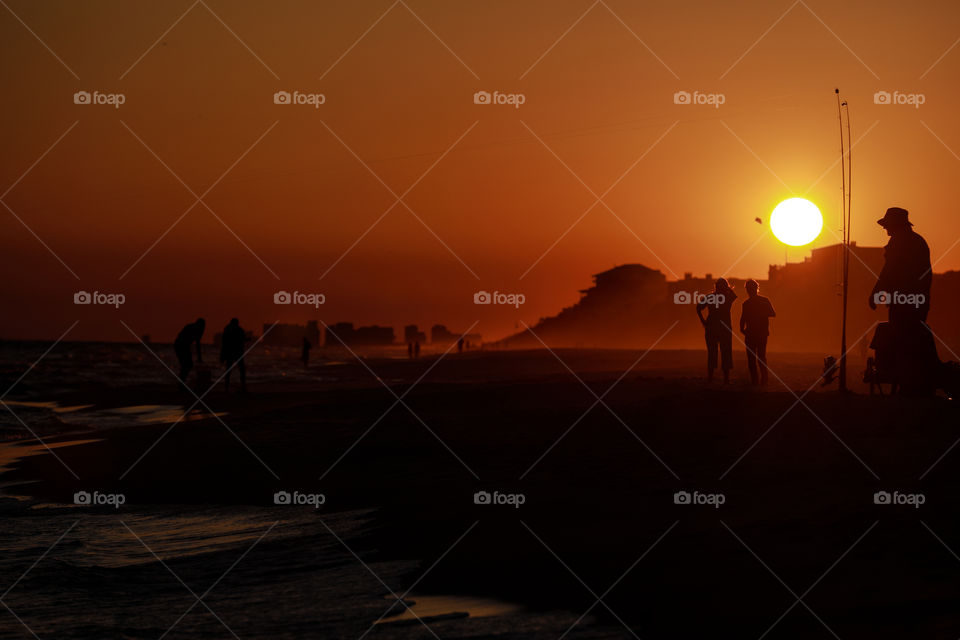 Walking at the beach on sunset with orange sky in Florida