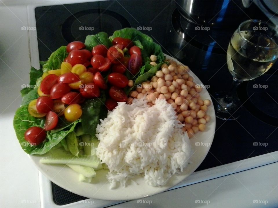 A lovely healthy meal. Rice, chick peas, dark green salad leaves and tomatoes with a nice glass of white wine