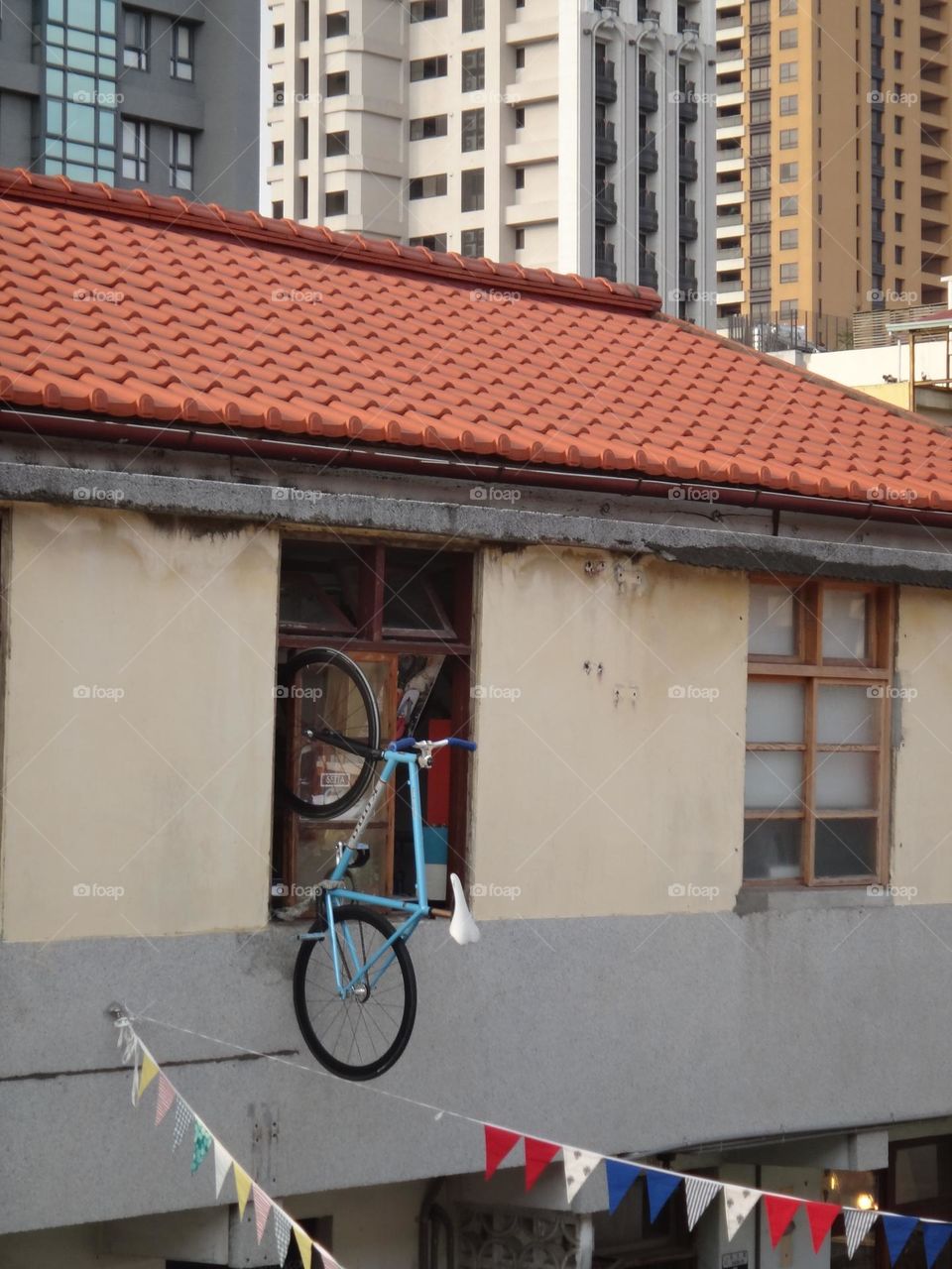 blue bicycle hanging on building window