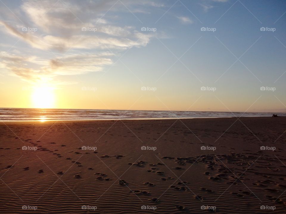 Sunset at beach sandy footprints