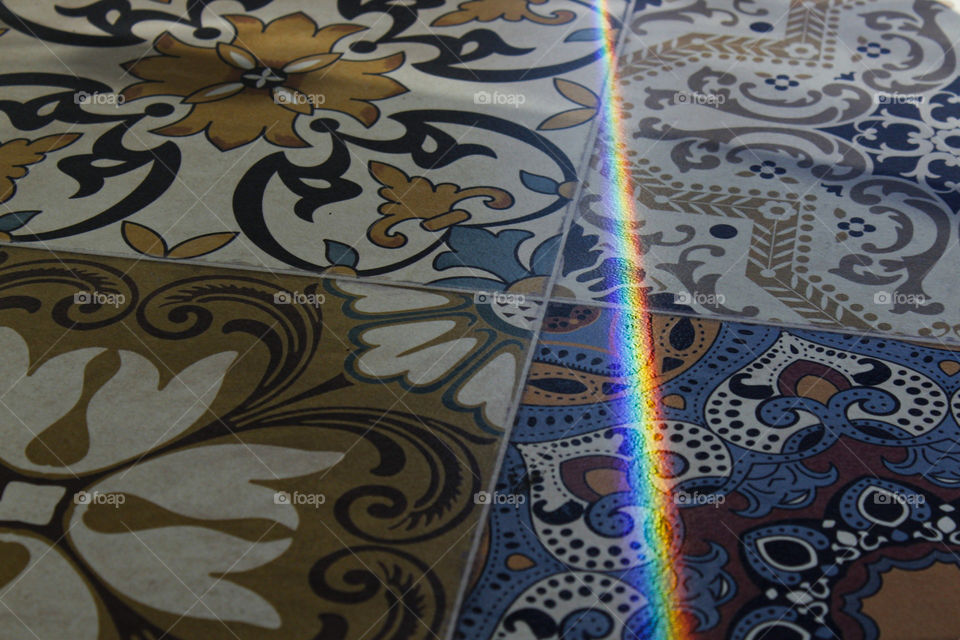 beautiful colorful rainbow projected in an also colorful floor