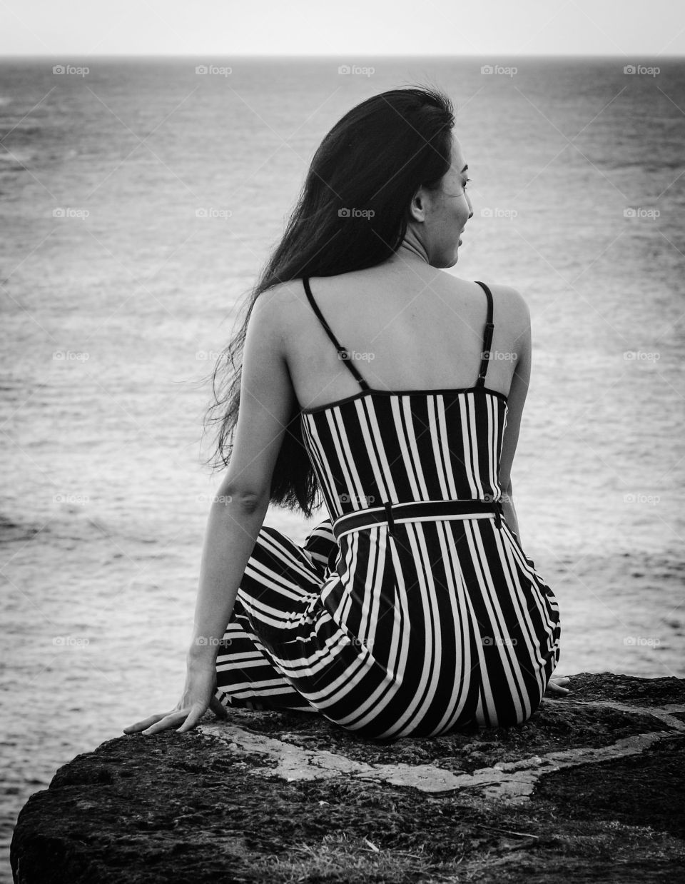 Asian woman looks out over the sea