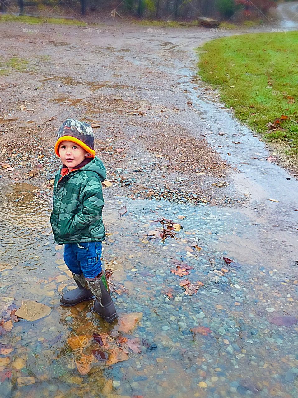 Boy child playing in puddles