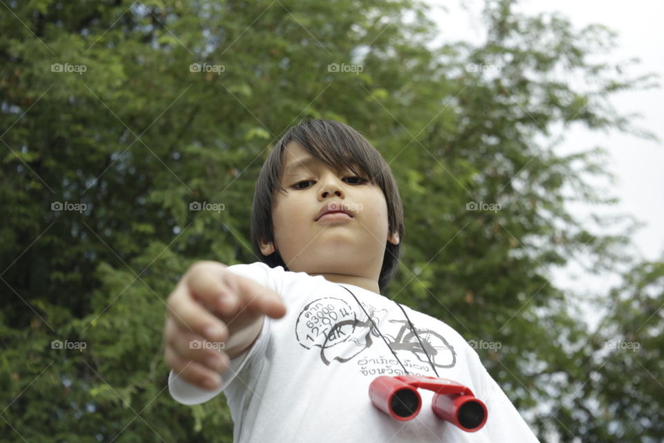 young Asian boy with long hair give a hand straight looking at the camera