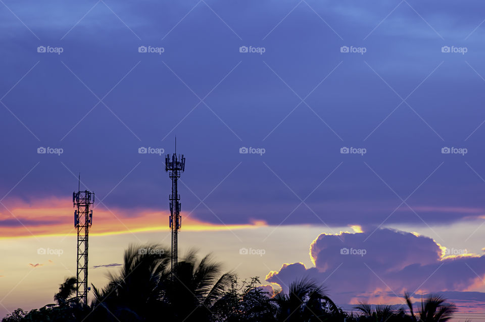 Evening sunset light is orange after the telephone receiver antenna.