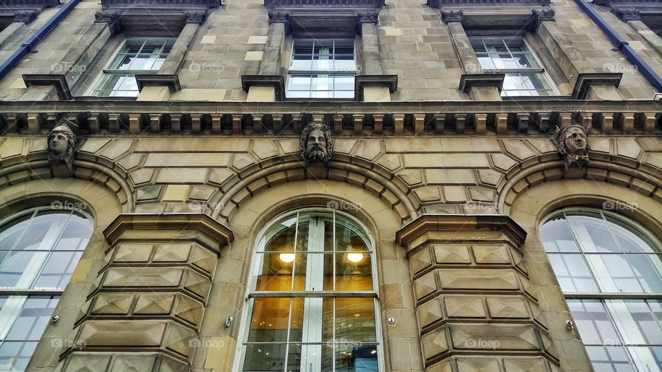 Three stone heads overlook the street from the custom house in Belfast,Northern Ireland