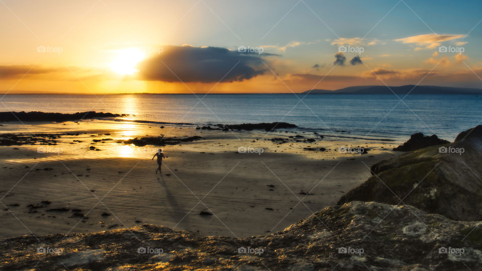 Man on the beach running towards Atlantic ocean