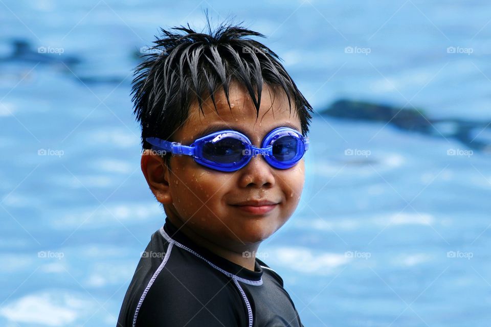 young boy with goggles in a swimming pool