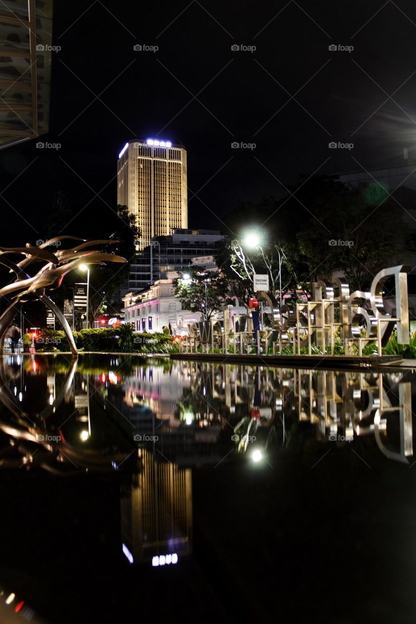 Reflection of parts of Singapore inside a fountain which looks like another world.