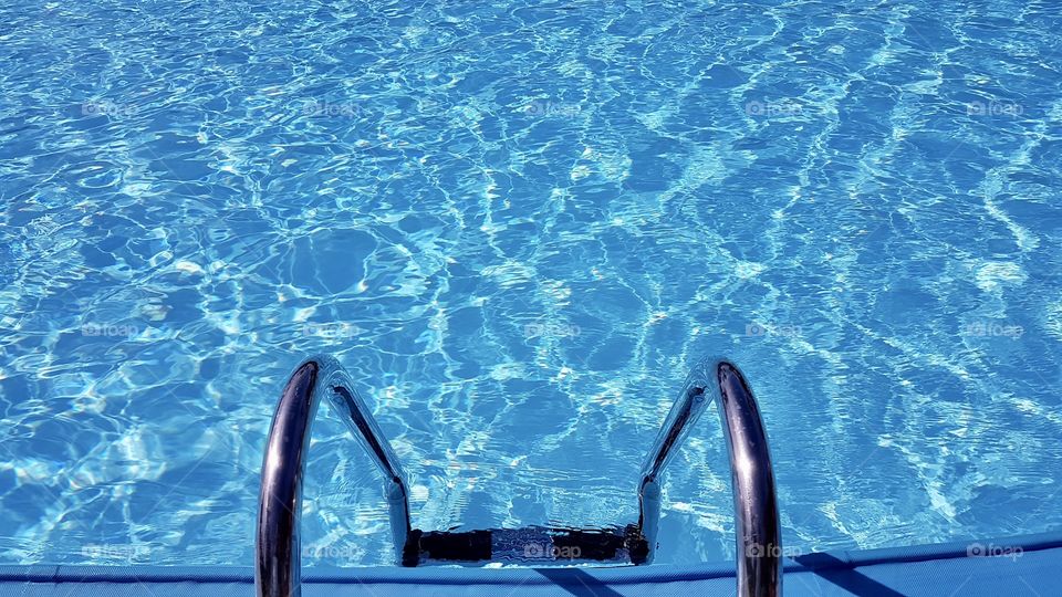Getting into a wonderful swimming pool with nice water by a ladder on a sunny day during the vacation -  på väg ner i en härlig pool en solig dag på semestern 