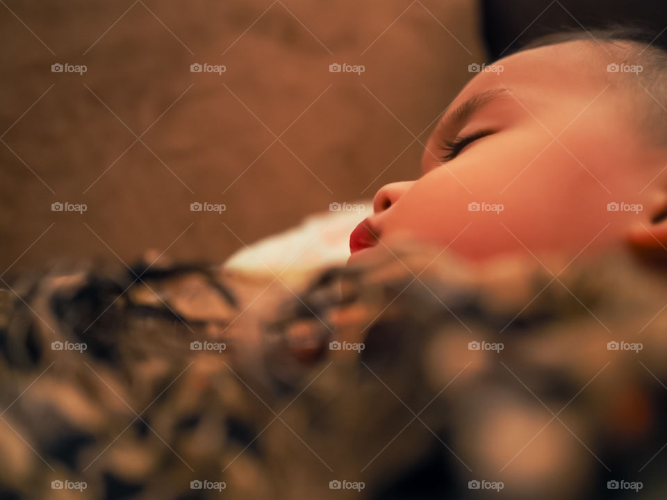 A child sleeping in position of coziness and contentment in a couch