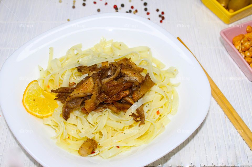 Rice noodles with oyster mushrooms on a white plate