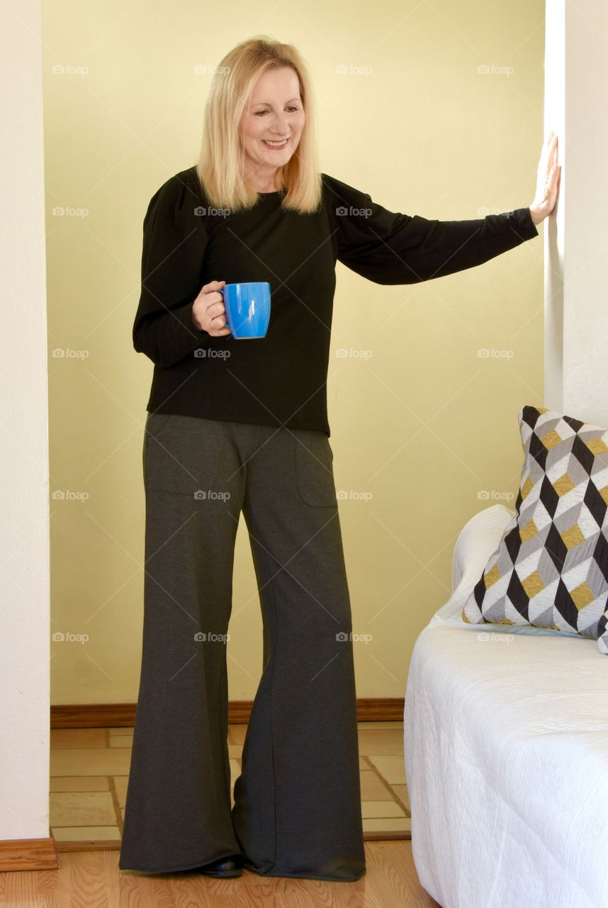 A blonde woman wearing KiraGrace pants and shirt