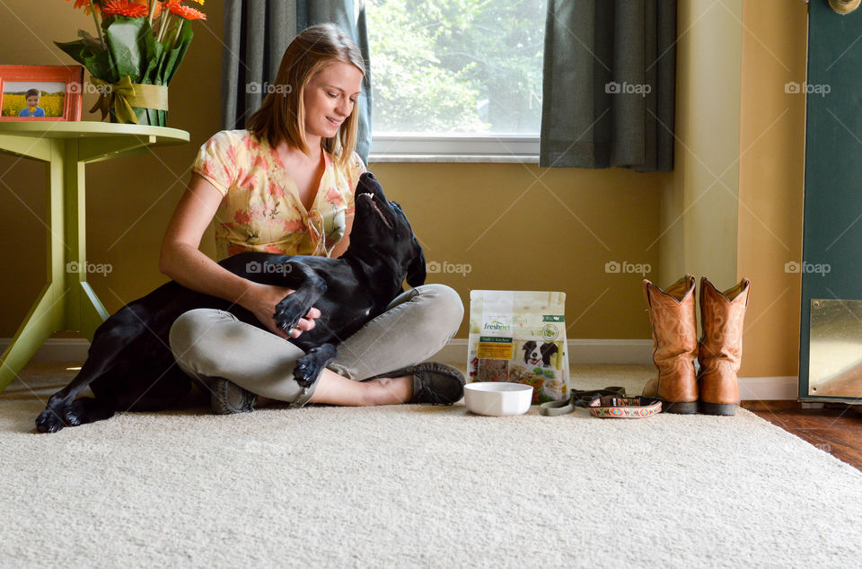 Woman sitting on the floor of a livingroom with her dog