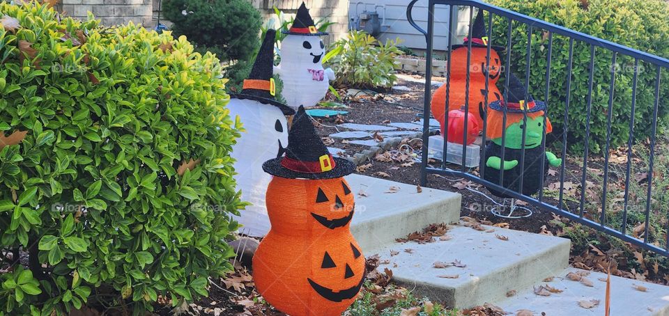 an assortment of spooky cute outdoor Halloween decorations surrounding the front steps of a suburban home in Oregon